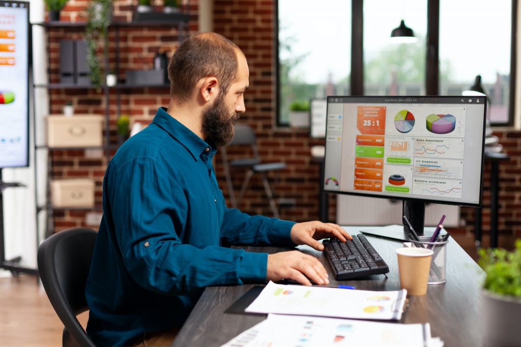 Entrepreneur man sitting at desk table typing management strategy on computer