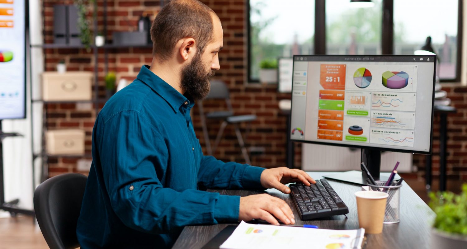 Entrepreneur man sitting at desk table typing management strategy on computer